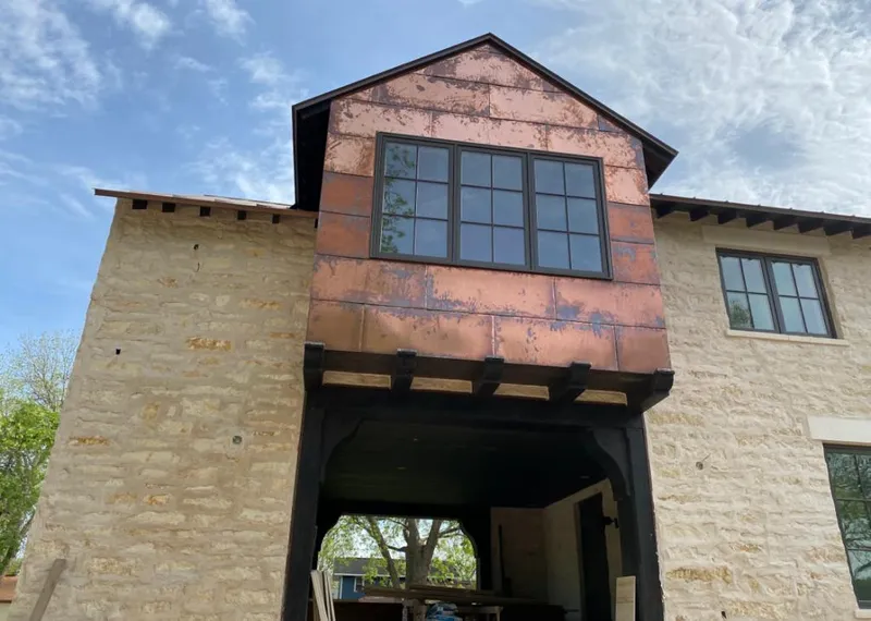 Copper metal panel facade on a stone building for Skylight Installation in Meadow Woods